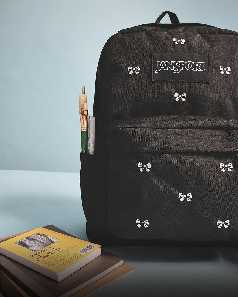 Black JanSport backpack with bow print